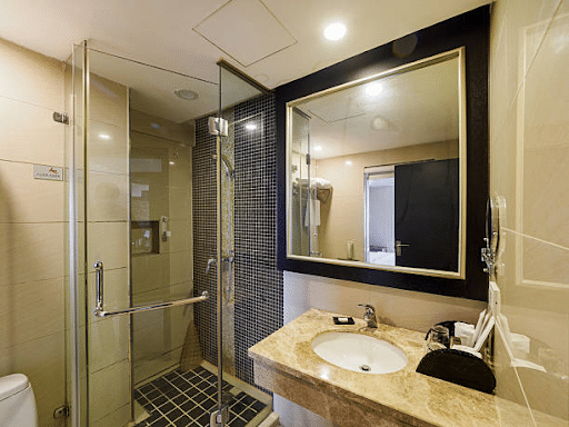 Modern lavatory providing glossy porcelain rest room tiles and porcelain toilet tiles on floor and partitions